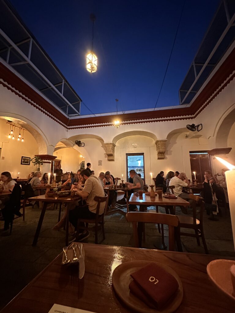 Romantic Michelin-star restaurant dining in Oaxaca Mexico, set in a stunning open courtyard with candlelit ambiance, showcasing exquisite Mexican cuisine and world-class flavours