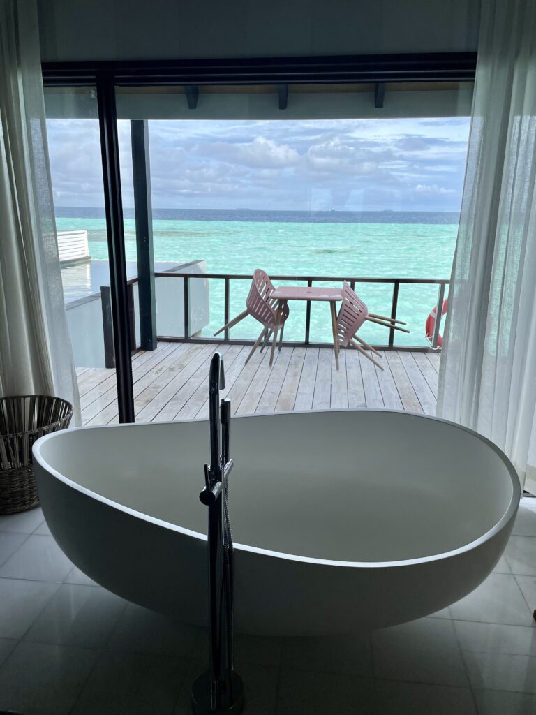 Unwind in a beautiful marble bathtub in the Wind Villa at Ozen Life Maadhoo, offering a luxurious soaking experience with stunning views.
