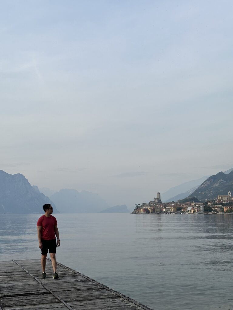 Scenic view from the pier on Lake Garda with calm water and mountain backdrop