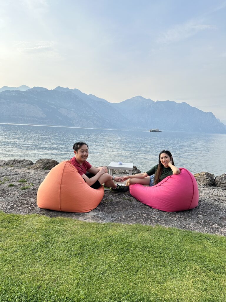 Bean bags by the water at Lake Garda with cocktails and sunset view