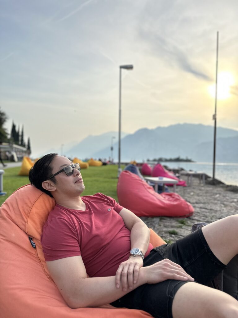 Relaxing on bean bags by Lake Garda with stunning waterfront views. One of our favourite spots in Lake Garda!
