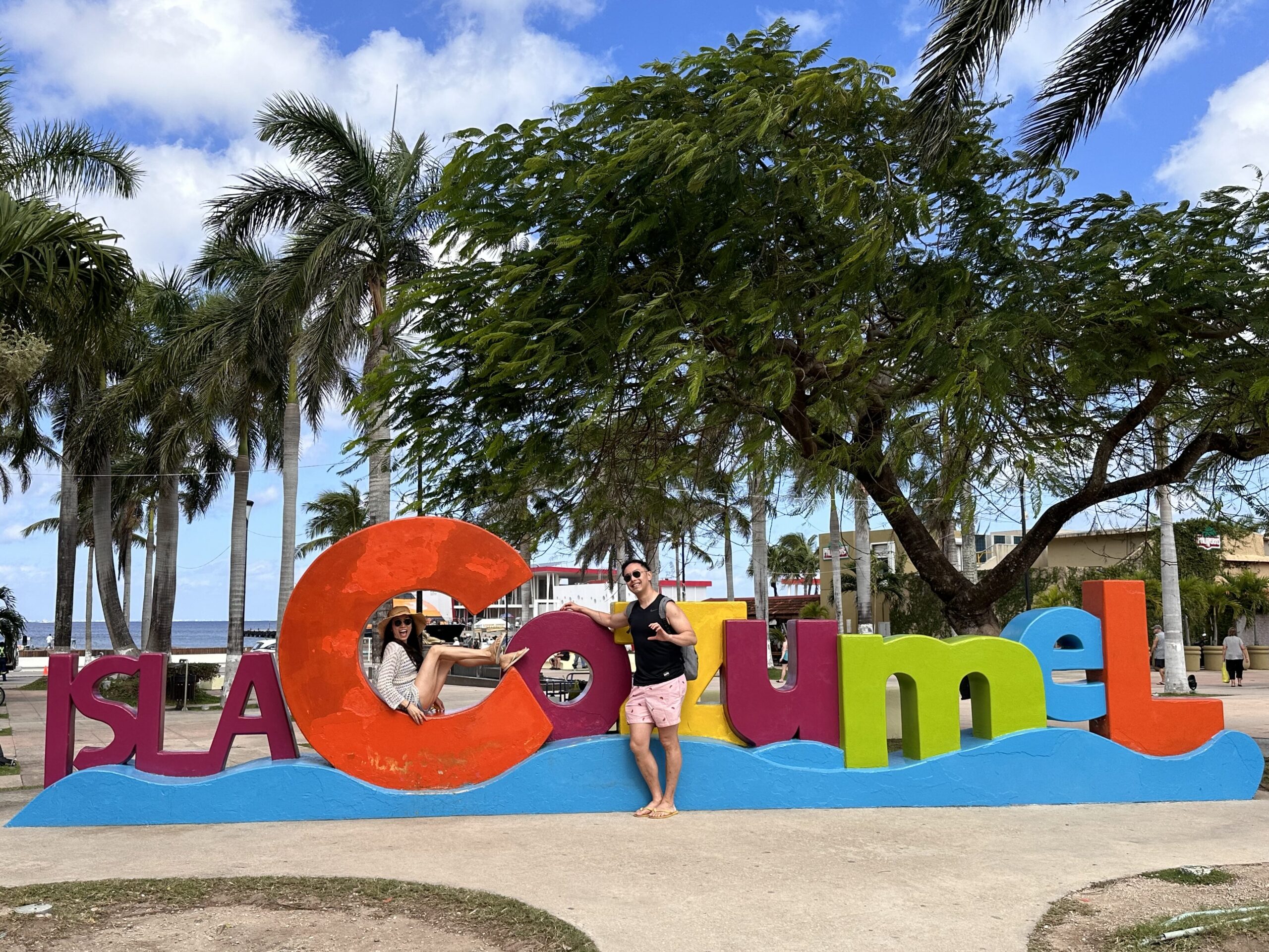 Us in the colorful sign of Isla Cozumel ahead of our snorkelling tour