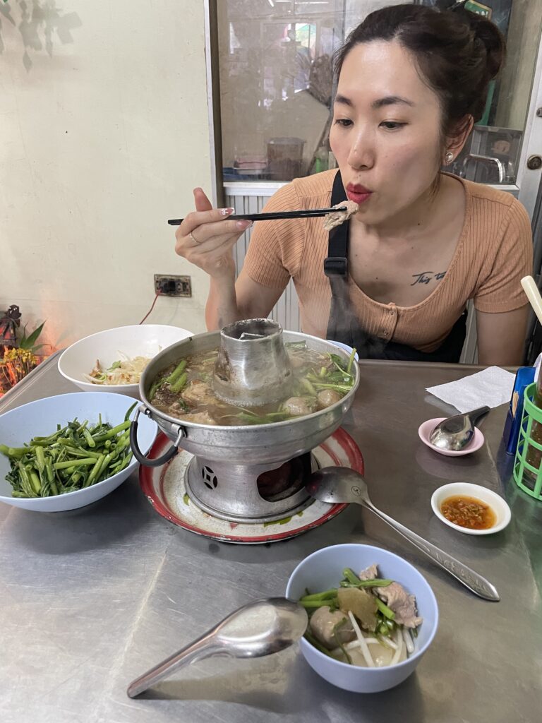 Enjoying succulent Thai beef hot pot at Heng Shun Seng restaurant in Bangkok, known for its rich broth and tender meat.