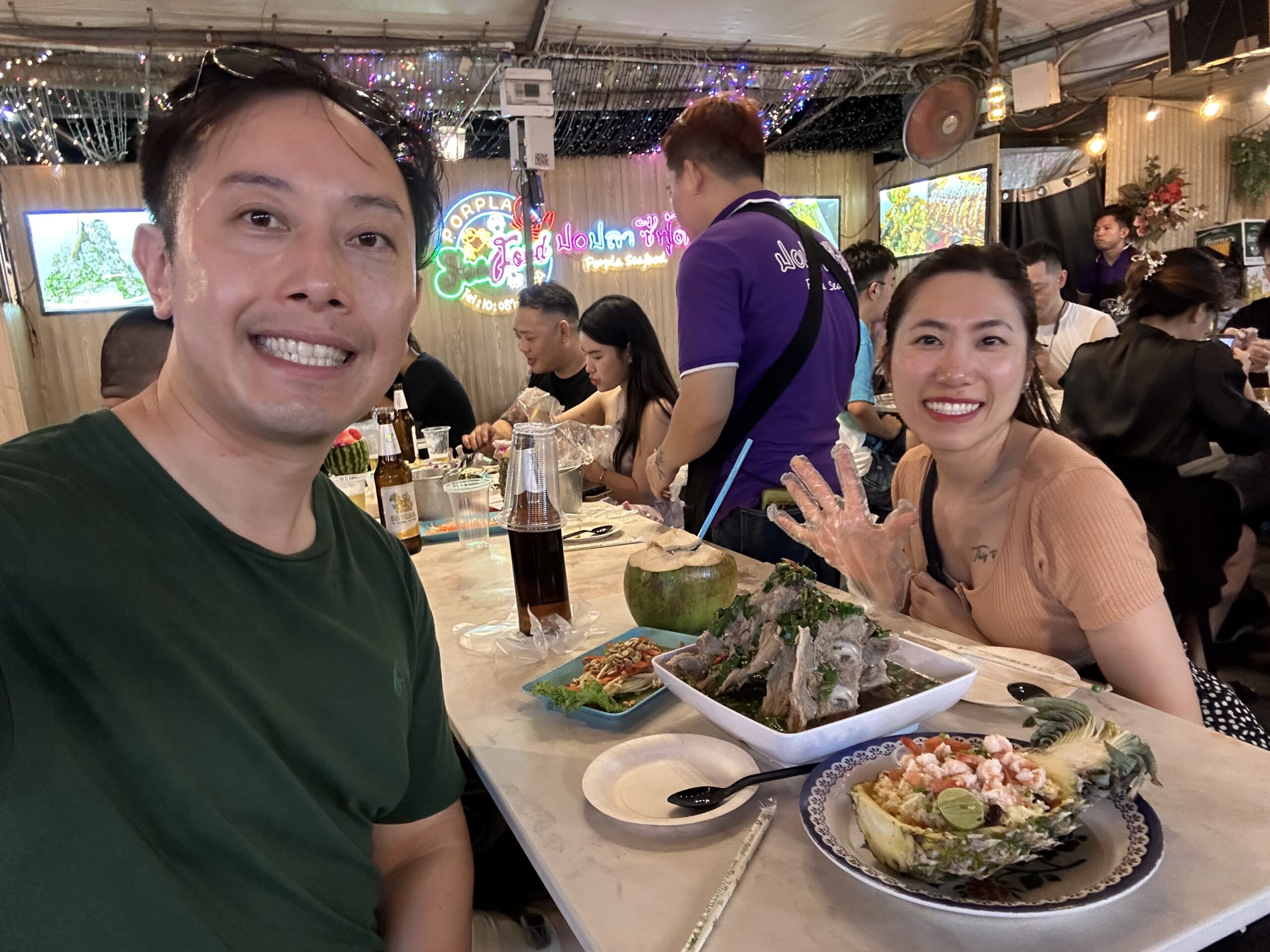 Eating spicy Volcano Ribs at Maeklong Noodles and Leng Zaab in Jodd Fairs night market, a must-try Bangkok street food dish.