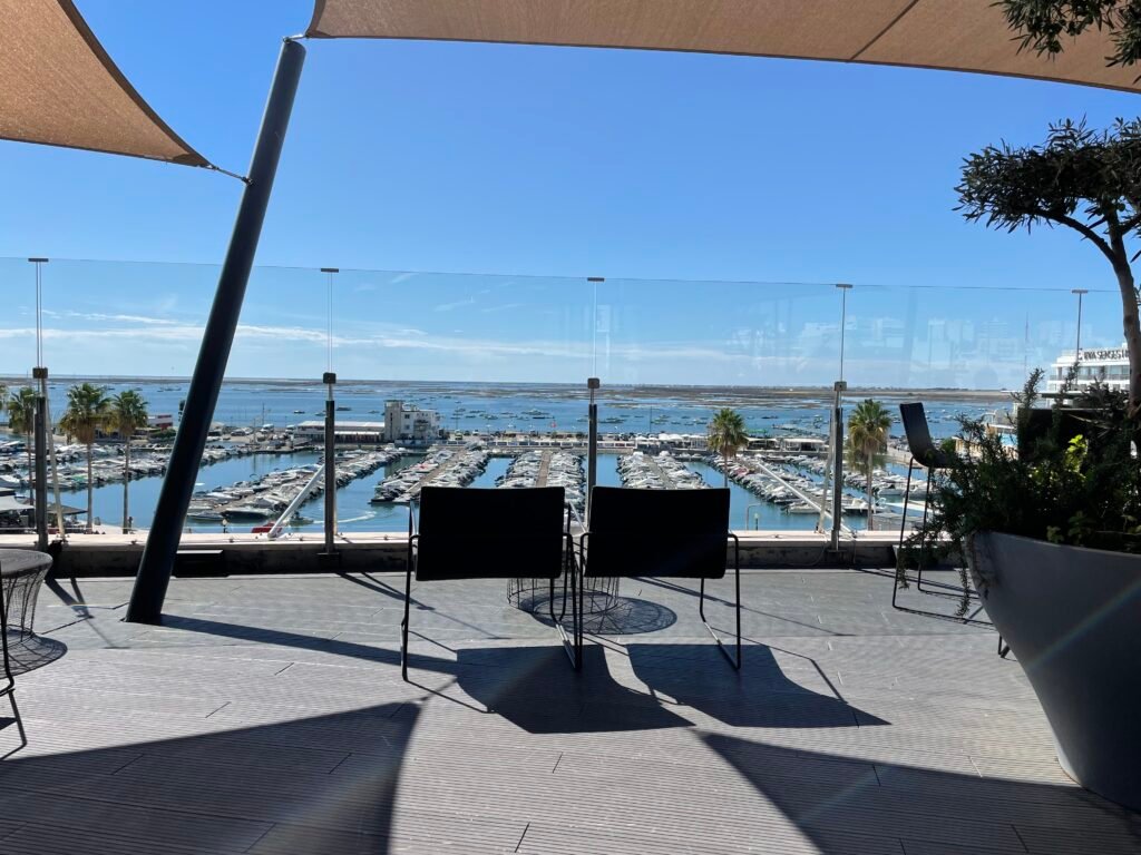 Elegant outdoor dining setup at Restaurante Ria Formosa with views of Faro marina