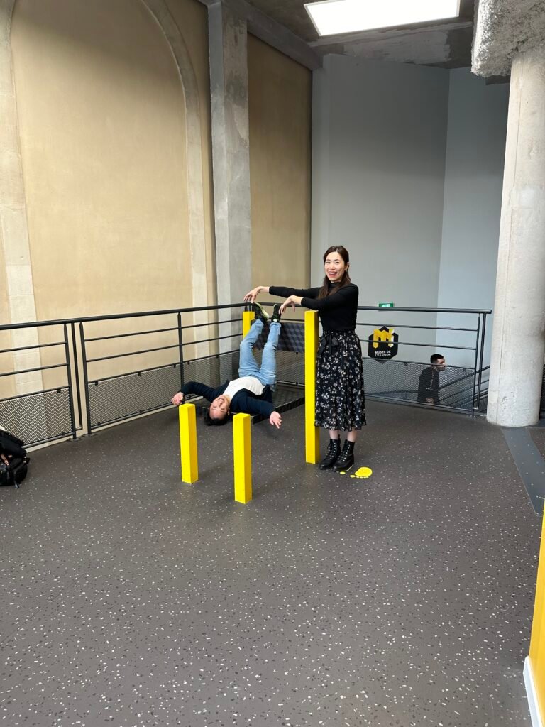 Visitors interacting with an optical illusion exhibit at the Museum of Illusions in Lyon, where fun and mind-bending visuals create a playful experience.