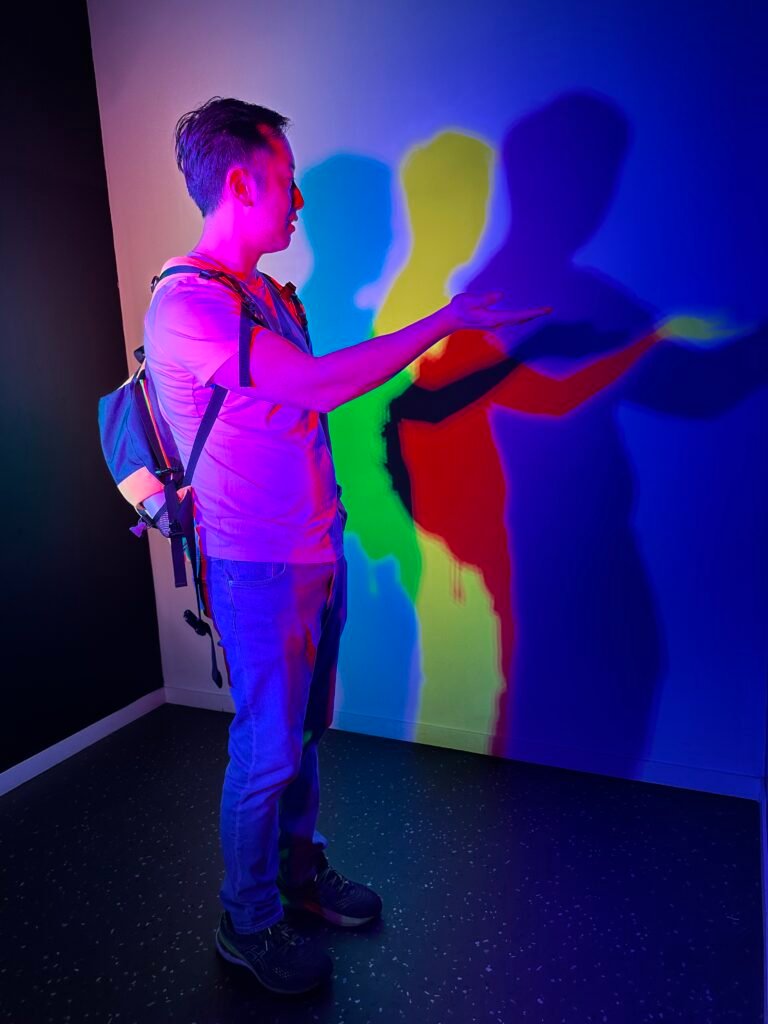 Visitors exploring a colour-changing room at the Museum of Illusions in Lyon, where light and colours shift to create unique visual effects.