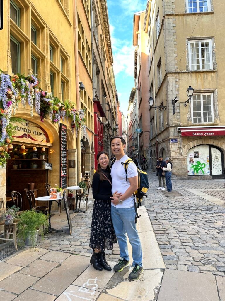 Tourists leisurely strolling through the picturesque streets of the Old Town in Lyon, surrounded by Renaissance-era buildings and vibrant local shops.