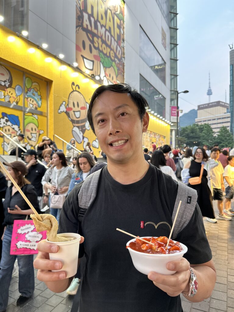 Variety of Korean street foods like tteokbokki, hotteok, and dumplings at Myeongdong Night Market in Seoul