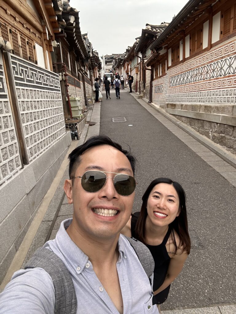 Visitors strolling through the narrow alleys of Bukchon Hanok Village, admiring traditional Korean hanok houses
