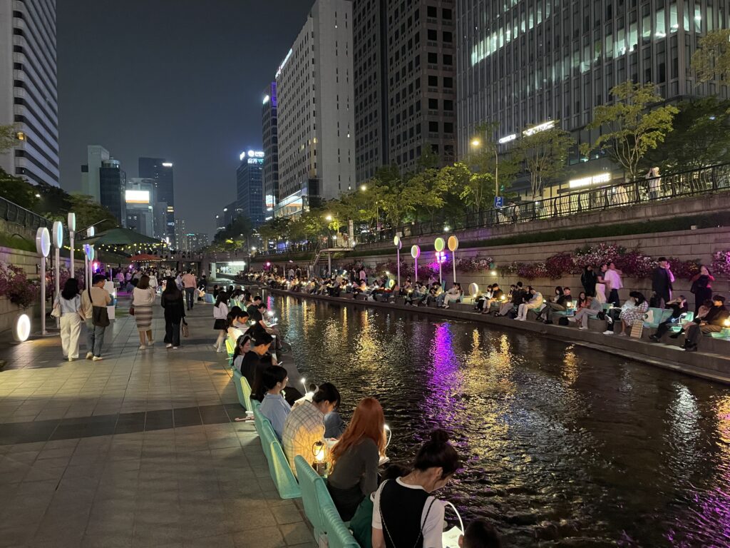 Seoul’s Cheonggyecheon Stream with people enjoying its open‑air book spaces and serene waterside setting