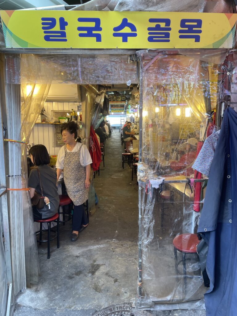 A bustling scene at Kalguksu Alley in Seoul, where diners enjoy traditional Korean knife‑cut noodles