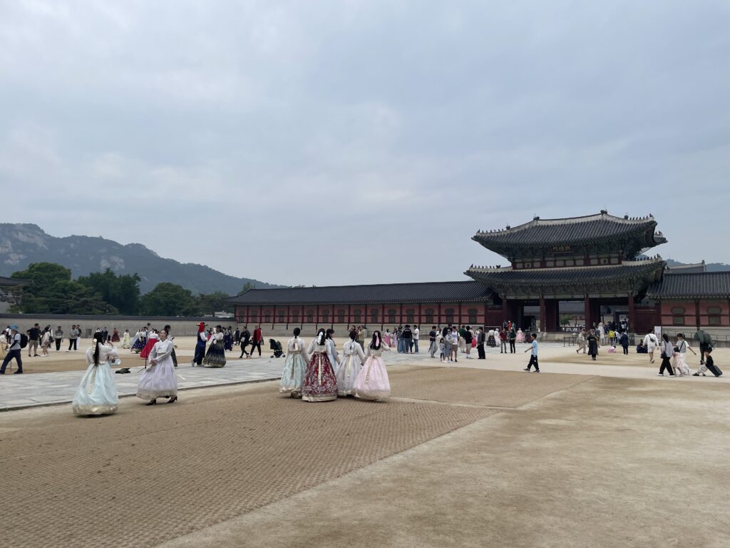 Exploring Gyeongbokgung Palace and its vast grounds with tourists in traditional Hanbok