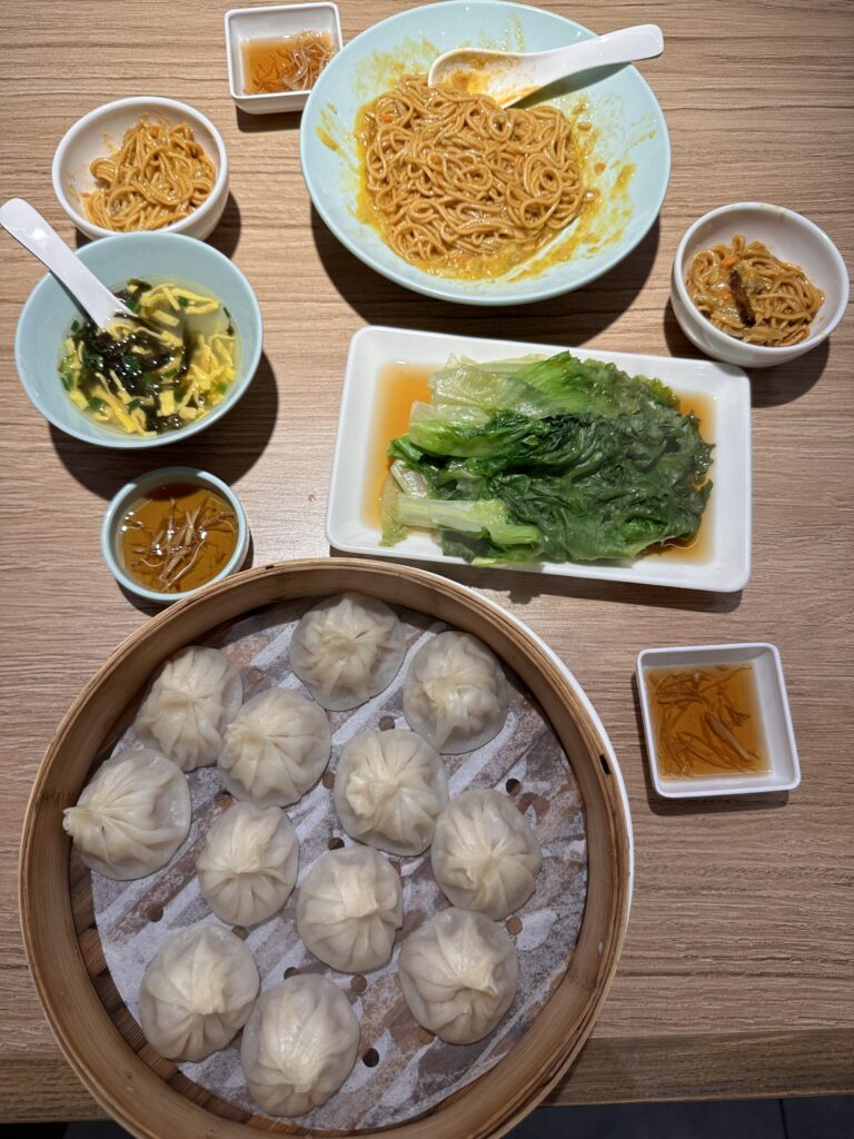 Close-up of freshly steamed xiaolongbao dumplings in a bamboo basket at a Shanghai restaurant