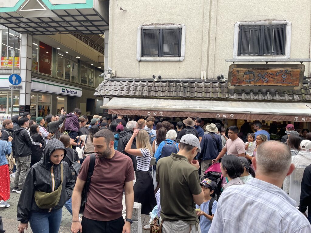 Travelers outside Nakatanidou mochi shop in Nara, Japan, known for its fast and entertaining mochi-pounding demonstrations and fresh yomogi mochi.