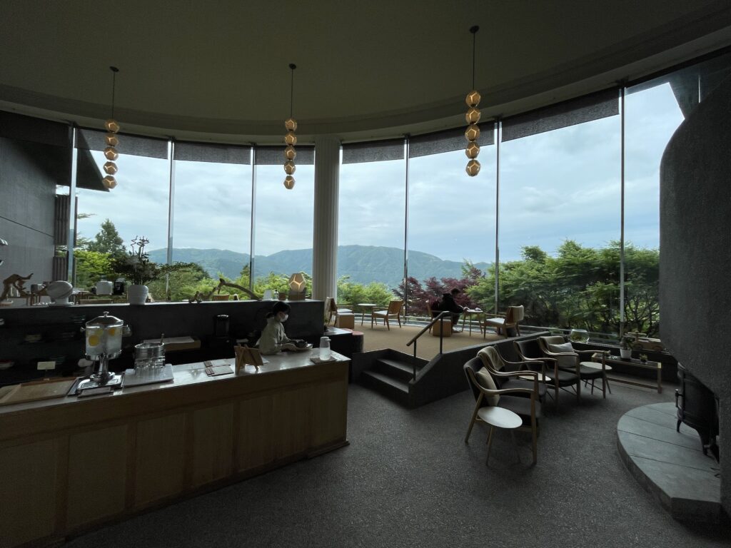 Stylish ryokan lobby offering panoramic views of lush hills and trees at Hakone Gora Byakudan