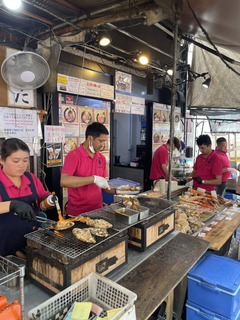 Tasting freshly cooked scallops at Tsukiji Market Tokyo Japan
