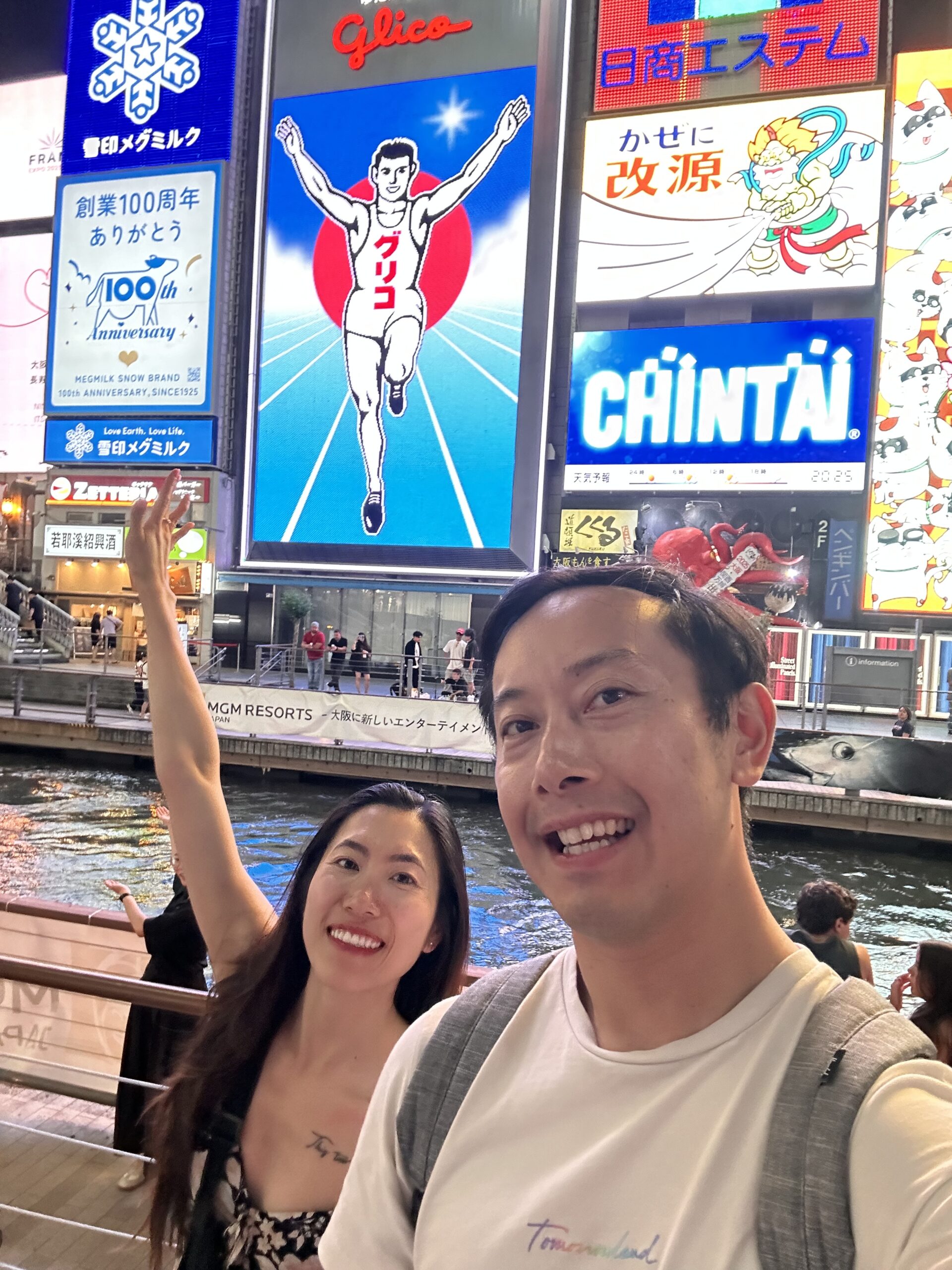 Couple wandering Dotonbori street food stalls in Osaka, famous nightlife and food district in Japan