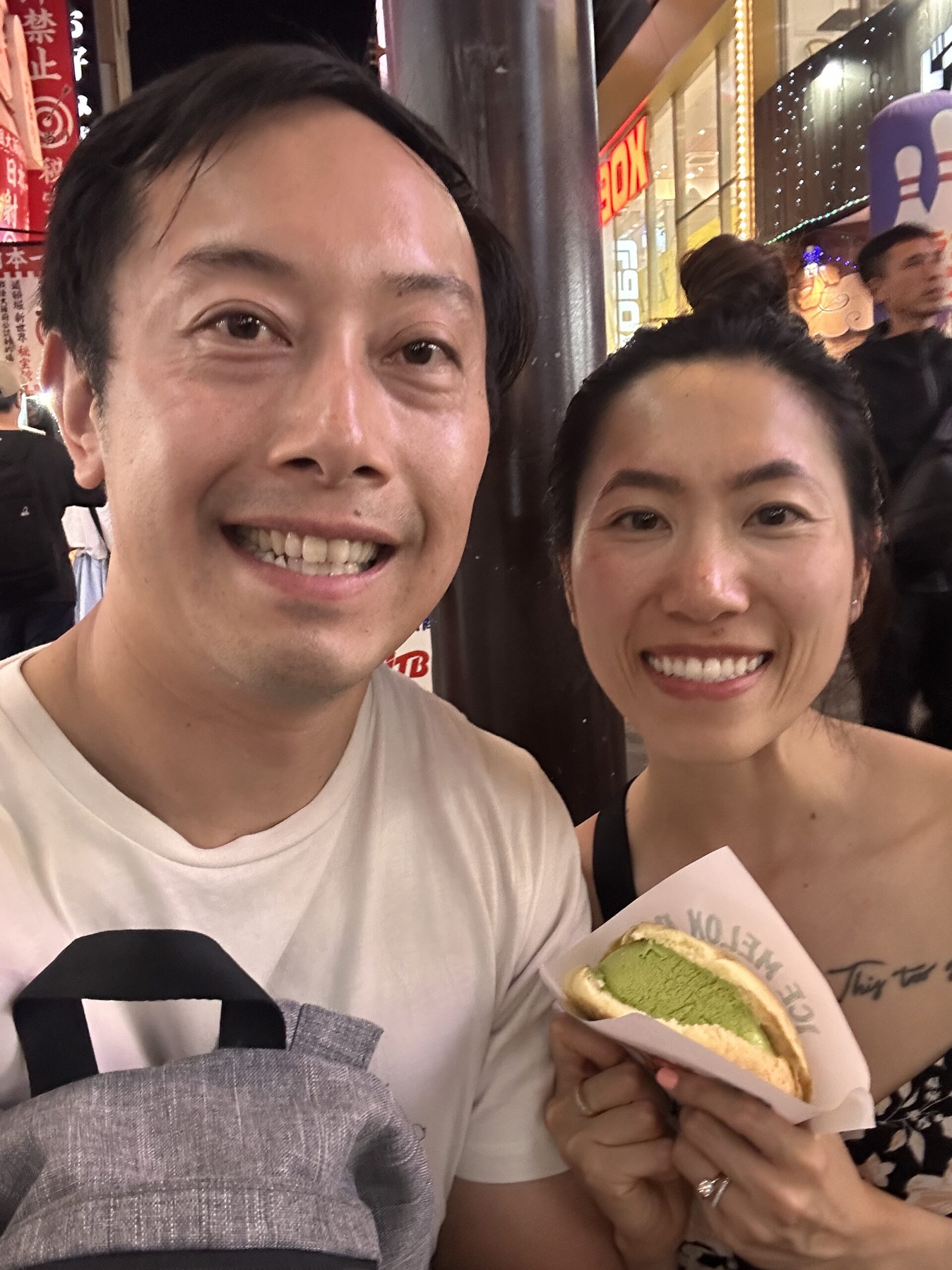 Couple enjoying melon pan dessert with matcha ice cream flavor, popular Japanese sweet treat in Osaka