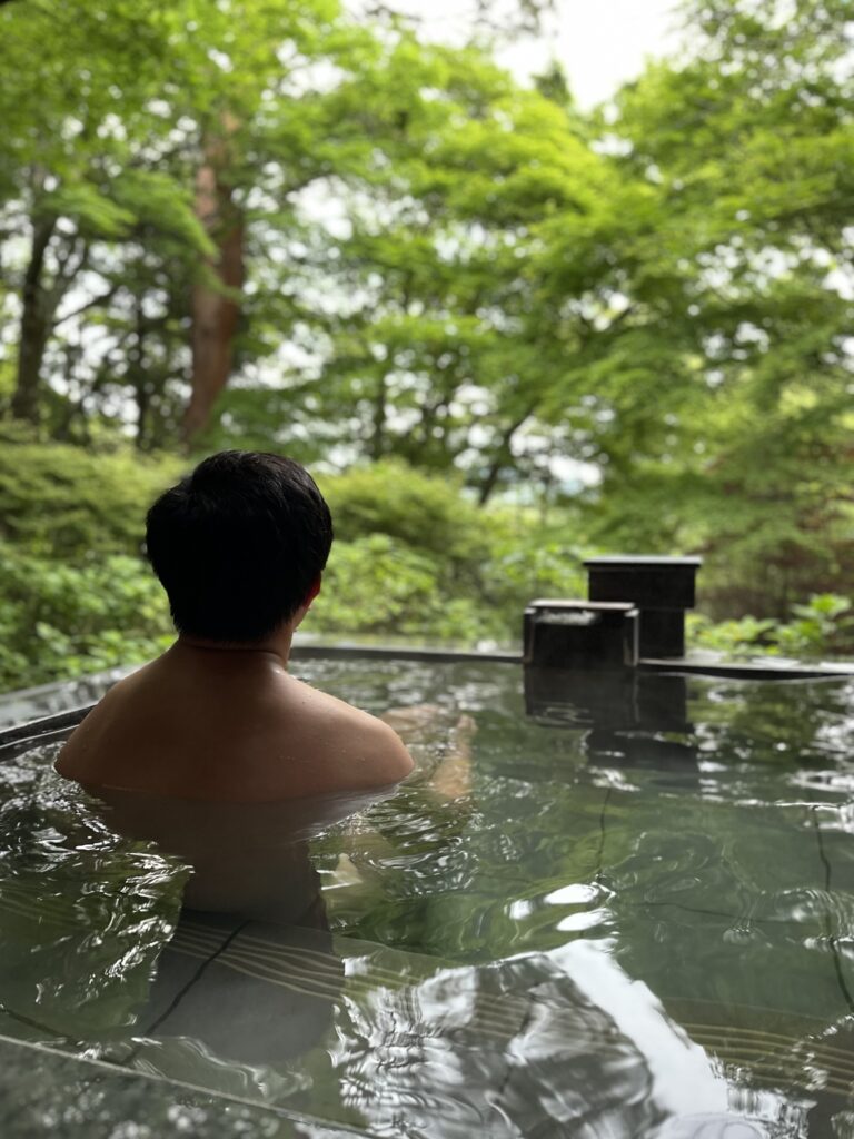 Private open-air onsen bath overlooking lush forest views