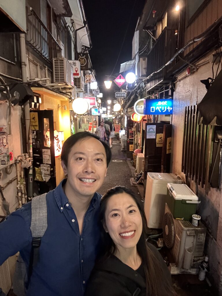 Couple exploring the narrow alley bars of Golden Gai in Shinjuku Tokyo