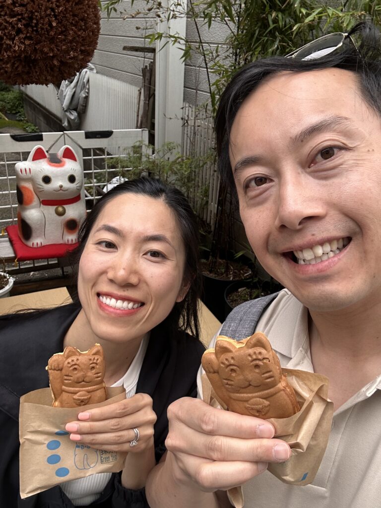 Couple savoring cute beckoning cat cakes at RARASAND cafe near Tokyo’s Gotokuji Temple