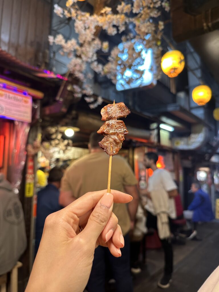 Enjoying traditional street food yakitori in Omoide Yokocho Tokyo experiences