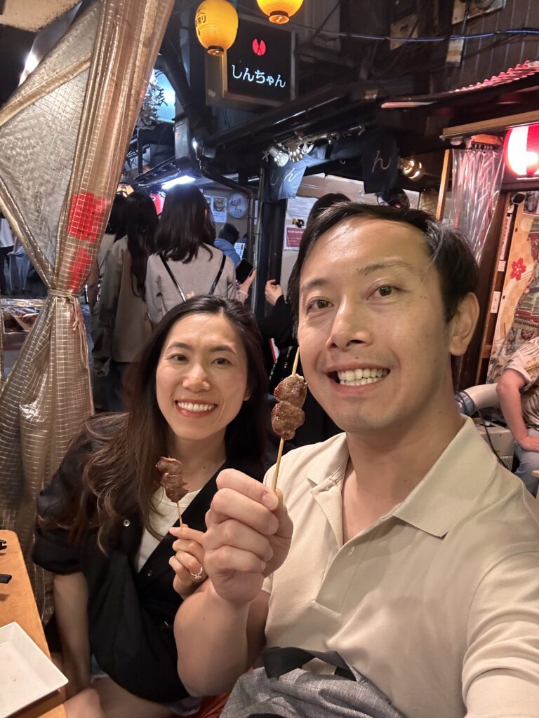 Travelers tasting grilled yakitori in narrow alley of Omoide Yokocho Tokyo experiences