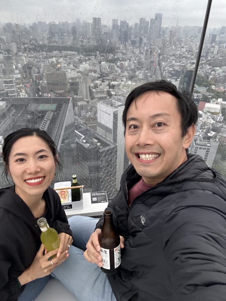 Couple taking photos at Shibuya Sky rooftop observation deck