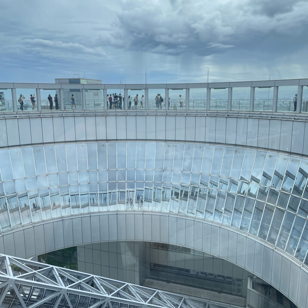 Two glass-and-steel towers of the Umeda Sky Building joined at the top by a circular observation deck.