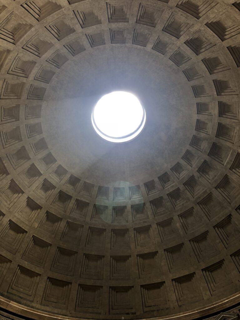Interior of the Pantheon in Rome with sunlight streaming through the oculus.