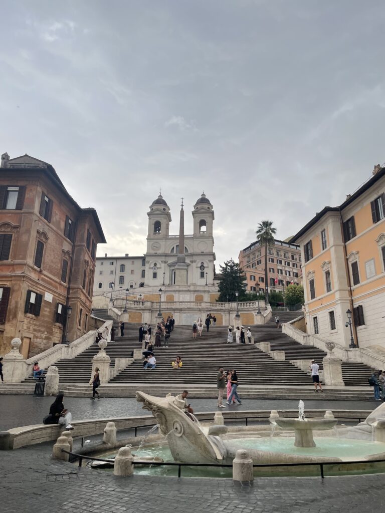 Spanish Steps leading up to Trinità dei Monti church, surrounded by historic buildings.