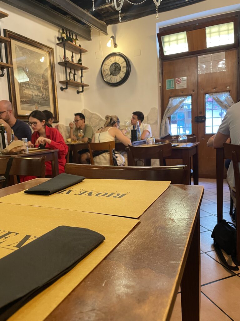 Intimate indoor dining at Rione IV Bistrot with cozy tables and warm lighting.